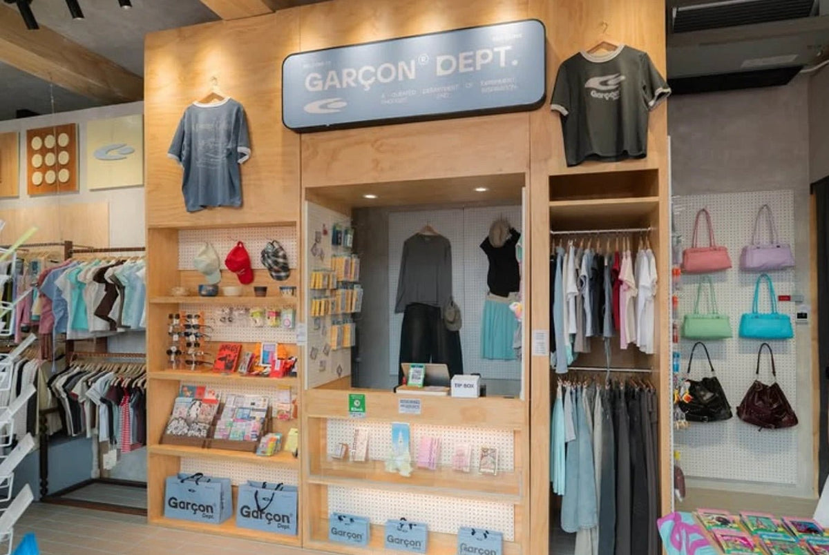 Ari interior: plywood display wall with tees, caps, sunglasses and bags