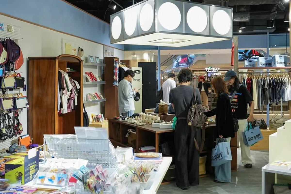Shoppers carrying blue Garçon Dept. bags in the CentralWorld store