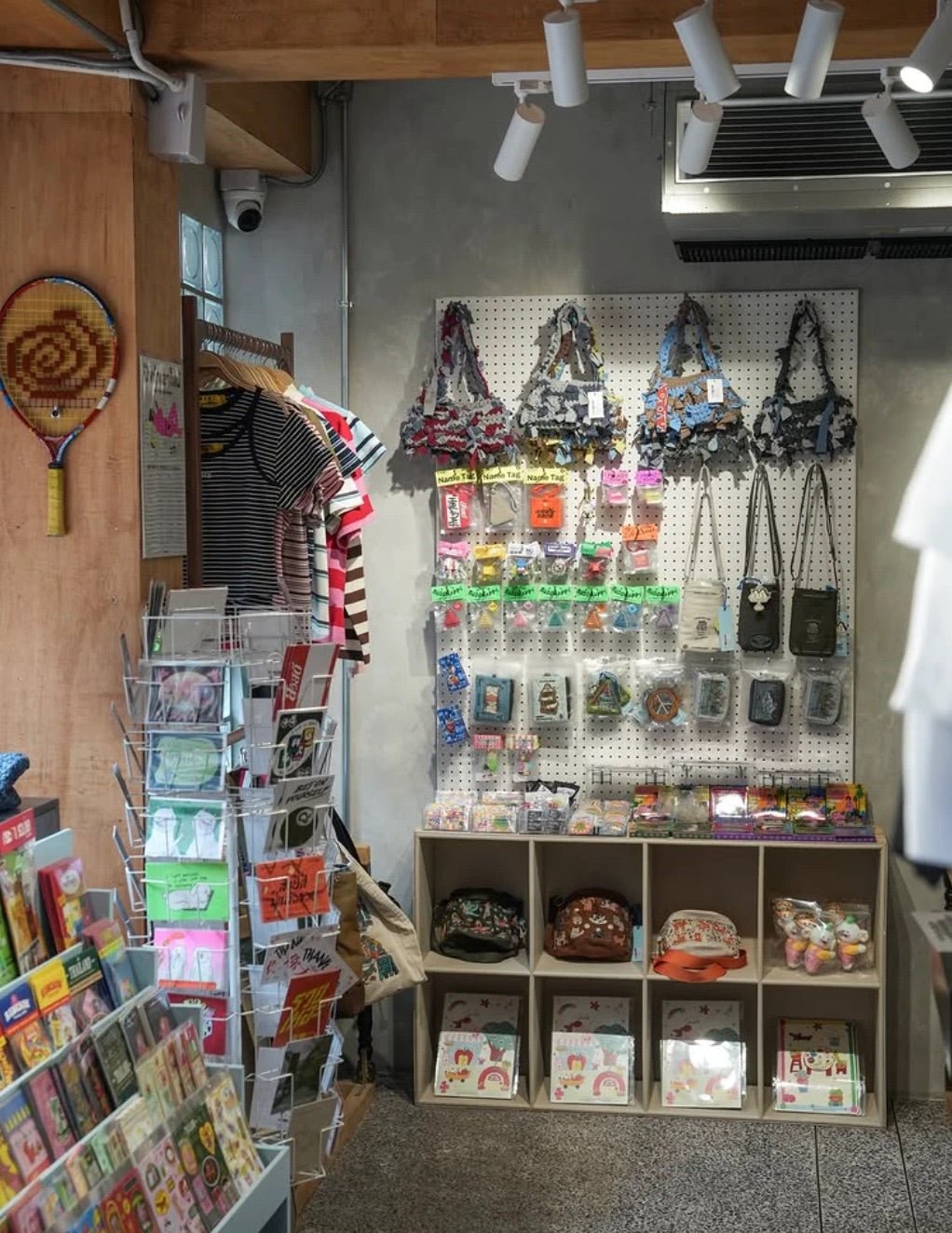 Songwat interior: pegboard wall of bags, stickers and accessories beside a card rack